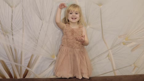 Happy-three-years-old-girl-make-faces-and-dancing.-Cute-blonde-child