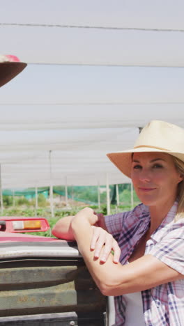 video of happy caucasian woman standing in front of tractor