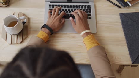 Vista-Aérea-De-Un-Hombre-Escribiendo-En-Una-Computadora-Portátil,-Trabajando-En-Una-Cafetería,-Concepto-De-Estilo-De-Vida-Empresarial