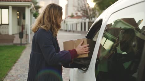 delivery man wearing protection mask and medical rubber gloves send a package to customer on the cargo van. happy smiling female