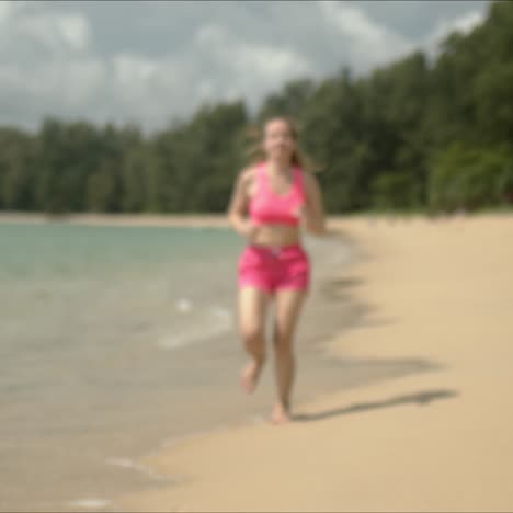 Mujer-Agradable-En-Traje-Rosa-Corriendo-En-La-Playa