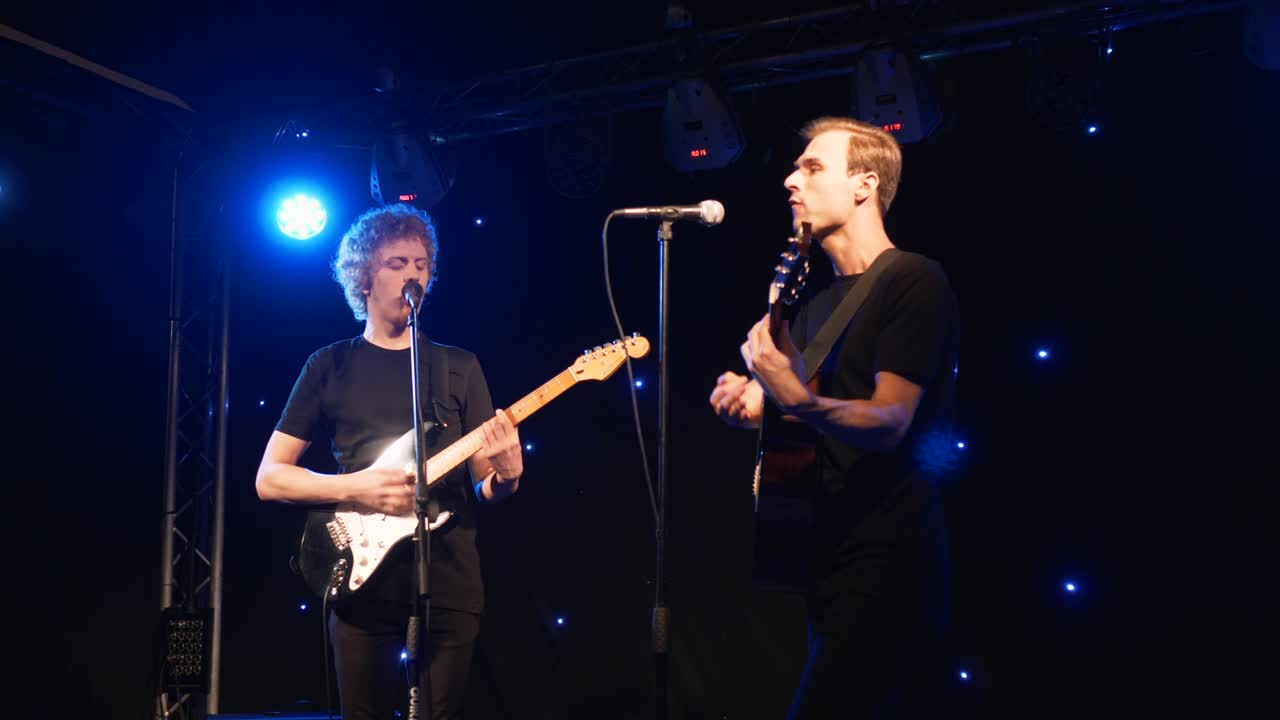 콘서트 록 밴드, 두 개의 전기 기타와 함께 무대에서 공연하는 가수, 뮤직비디오 크, 헤비 메탈 또는 록 그룹, 느린 동작 악기 연주 두 사람의 밴드