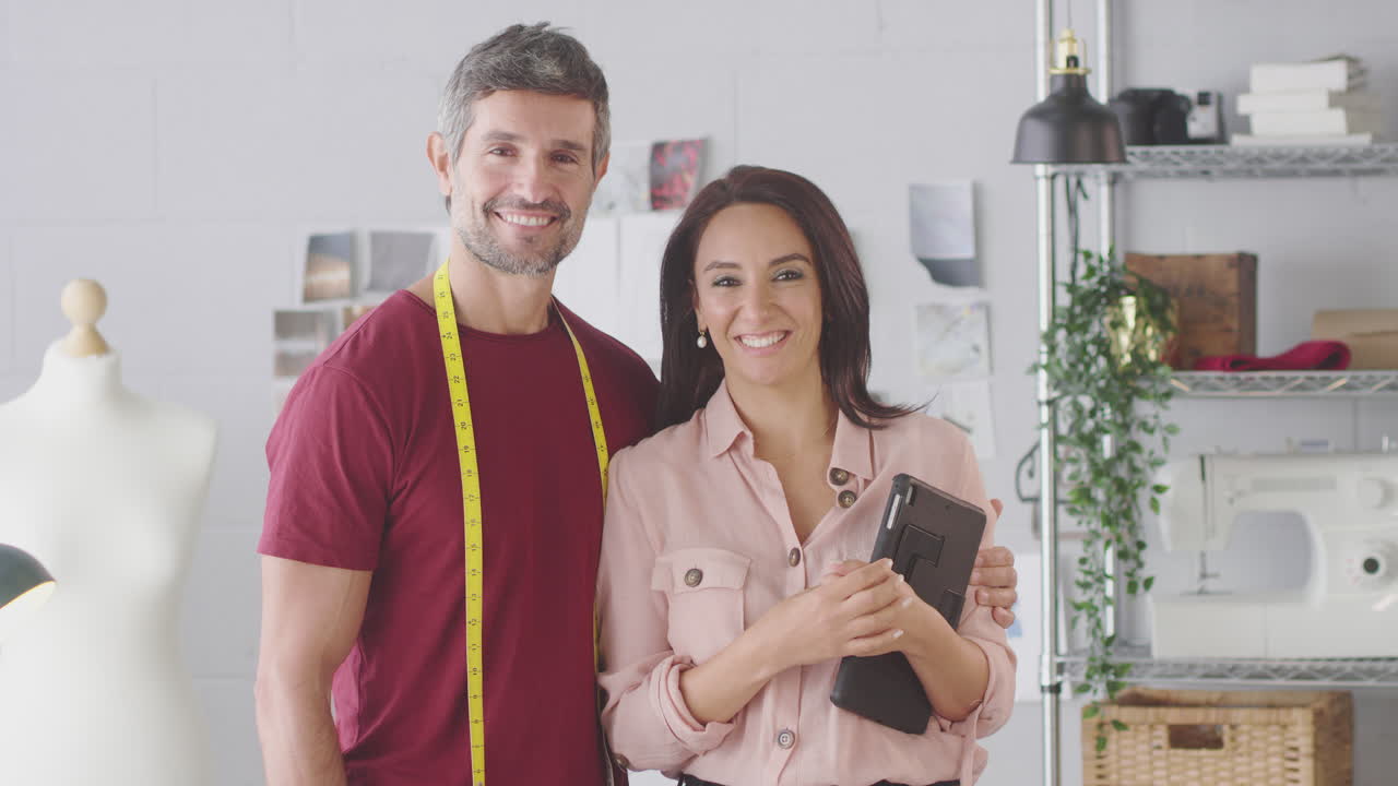 retrato de diseñadores de moda hombres y mujeres sonrientes con tableta digital trabajando juntos en el estudio
