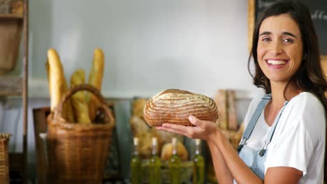 Smiling-woman-holding-a-loaf-of-bread