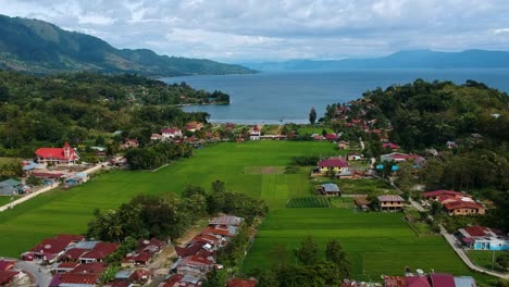 impressionante foto aérea do lago toba com aldeia, montanhas e água azul em sumatra, indonésia