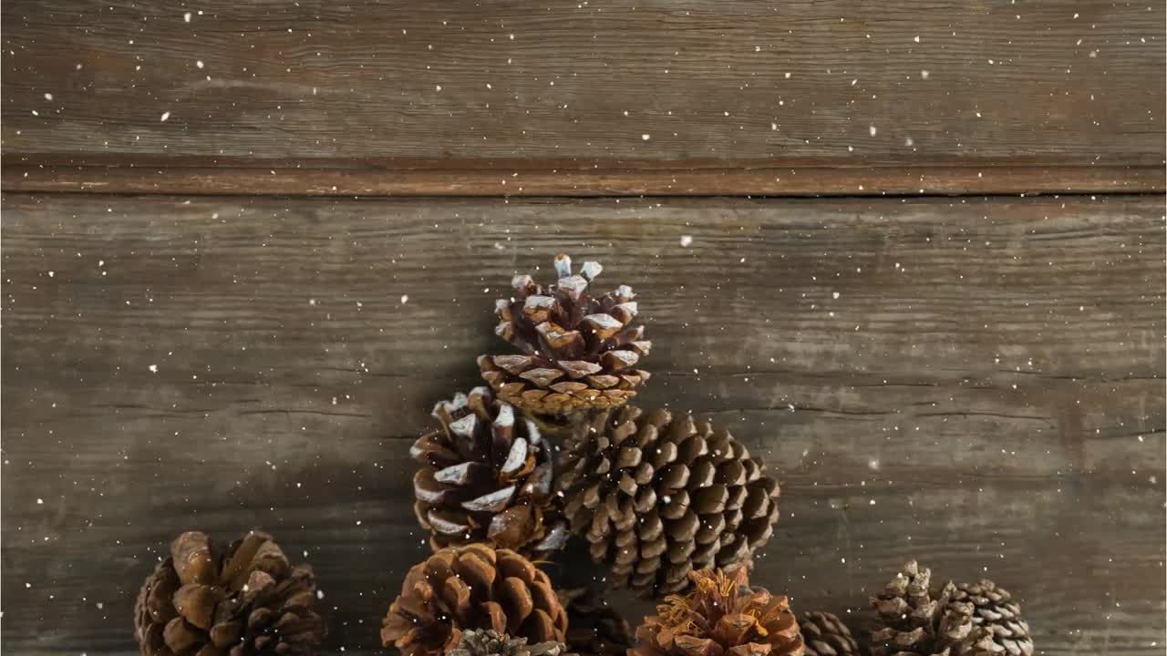 Animation of snow falling over pine cones on wood board