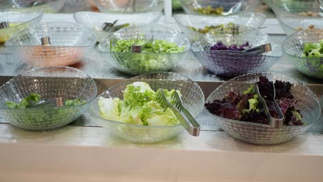 barra de ensalada con varias opciones de lechuga verde y roja