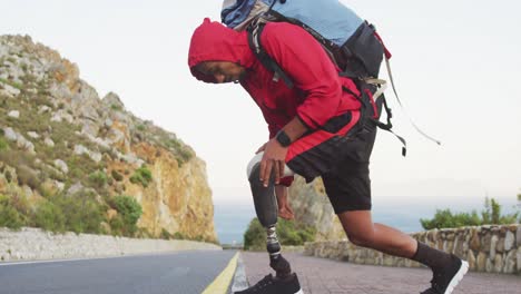 sporty mixed race man with prosthetic leg hiking