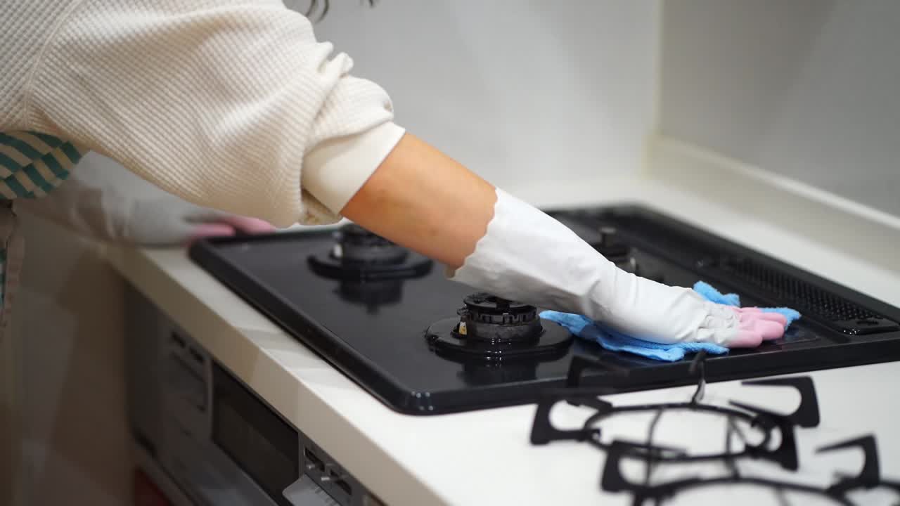 Una donna che pulisce un fornello a gas