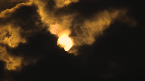 gran sol brillante se levanta a través de nubes oscuras en el cielo