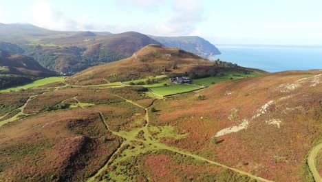 rural galés cubierto de brezo montaña ladera valle océano costa vista de órbita aérea izquierda