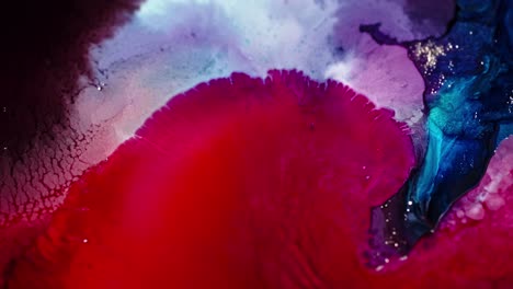 vibrant ink clouds diffusing in water, creating an abstract mix of red, blue, and purple hues