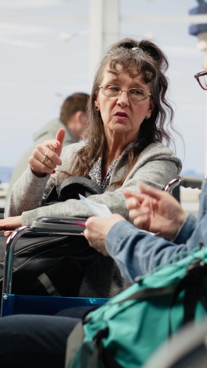 Video verticale: donna con disabilità, coppia anziana che viaggia insieme, nella lounge dell'aeroporto
