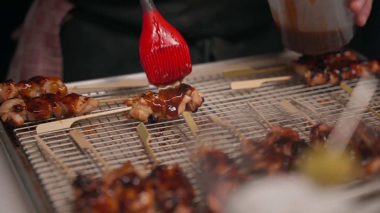 Una salsa saporita viene versata a filo su uno spiedino di pollo (slow motion 4K)