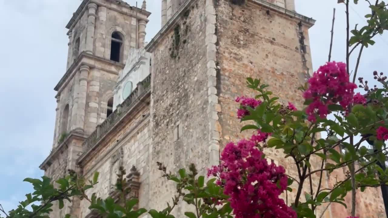 Handheld booming up shot of the belltowers at Templo de San Servacio in Valladolid, Mexico. 4K