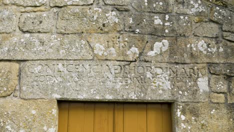 palabras grabadas que establecen la histórica capilla de san vitoiro por encima de las puertas de madera