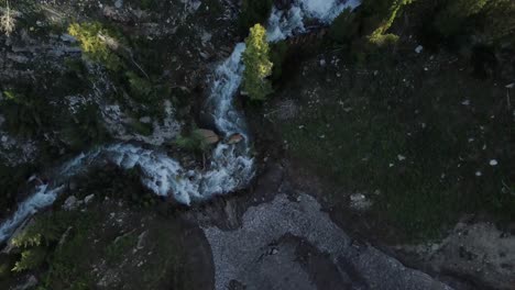 overhead flight over a running river during spring run off in a canyon at the close of skiing season