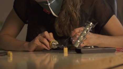 Woman-electronics-engineer-is-soldering-an-electric-battery-in-her-workshop