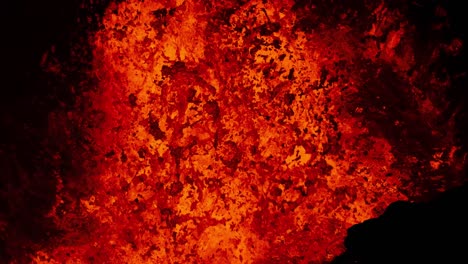 primer plano extremo de lava fundida explotando desde el cráter de un volcán activo