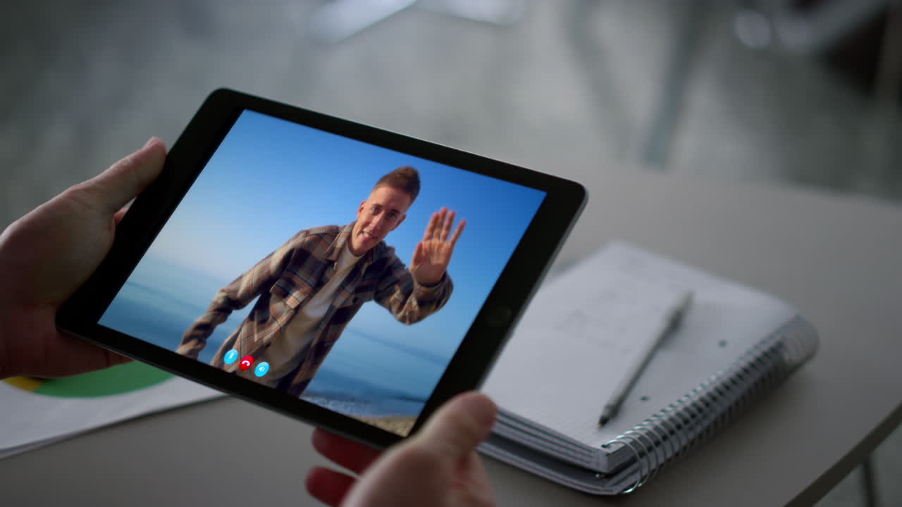 Video call on a tablet with a man on the beach