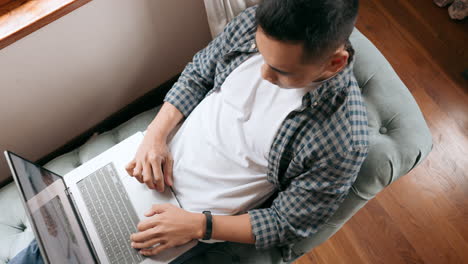 hombre trabajando en una computadora portátil en casa