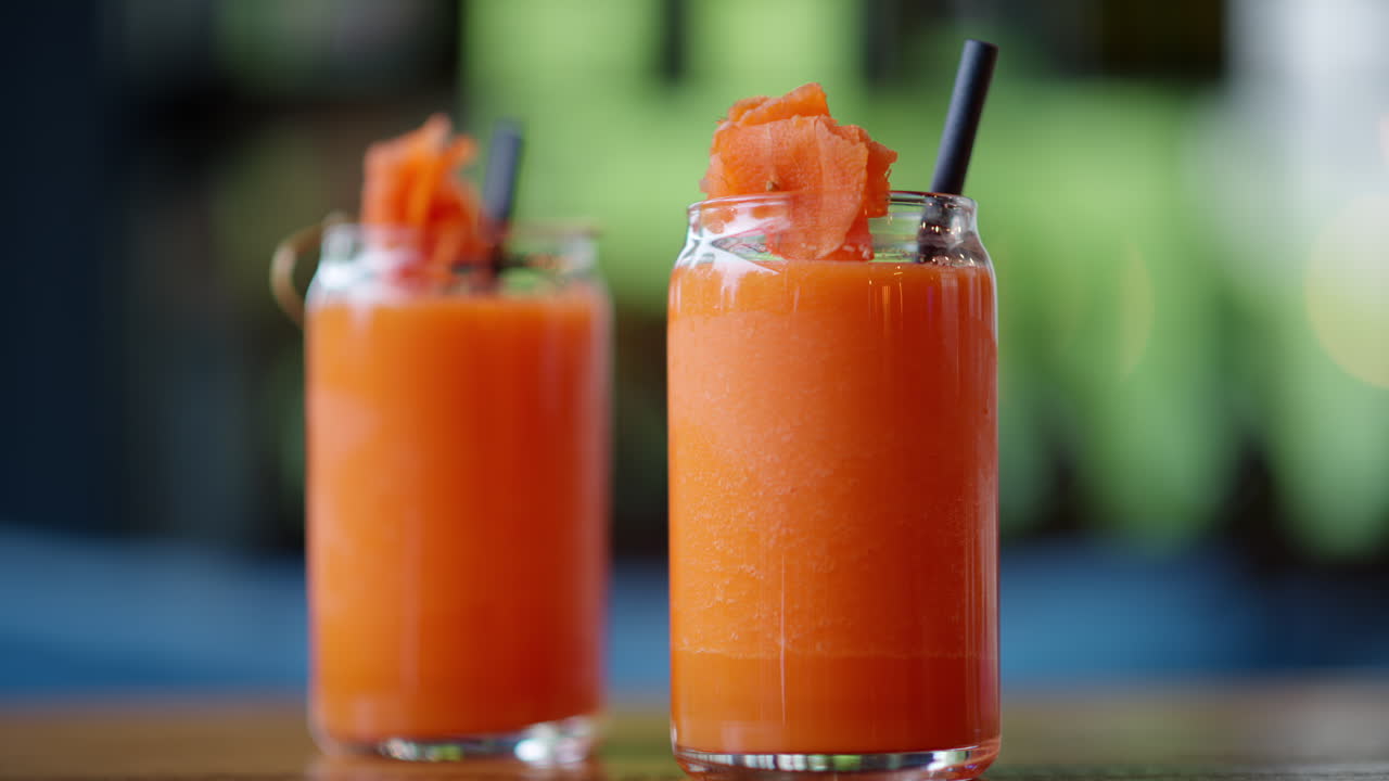 Two glasses of carrot juice, on the table at a restaurant