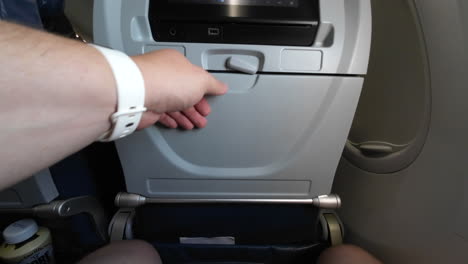doblar una mesa de bandeja de avión y bloquearla en posición vertical
