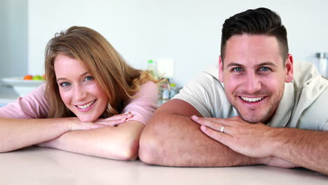 happy couple leaning on the counter smiling at camera