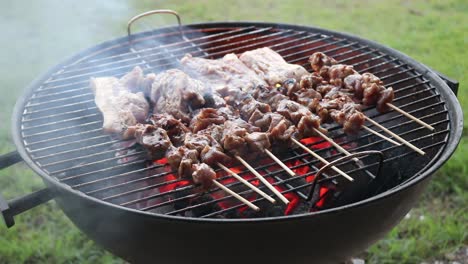 turning chicken skewers and pork spare ribs over on a charcoal bbq