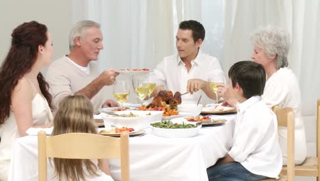 Panorama-of-parents,-children-and-grandparents-having-dinner-at-home