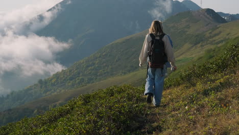 una mujer caminando por las montañas de niebla.