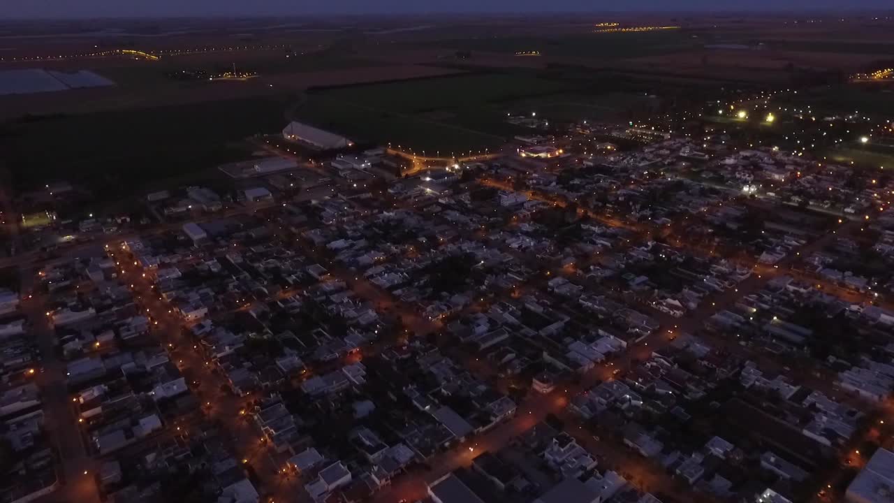 Aerial night drone view of the main access to a country town with the highway away on the horizon