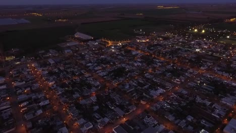 aerial night drone view of the main access to a country town with the highway away on the horizon