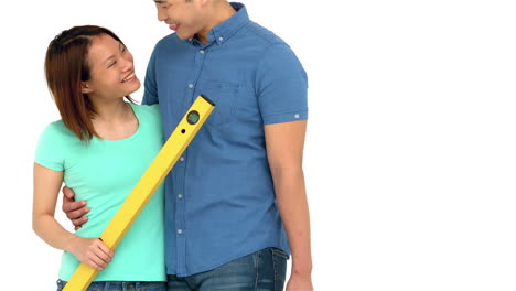 una pareja asiática sonriente con herramientas diy