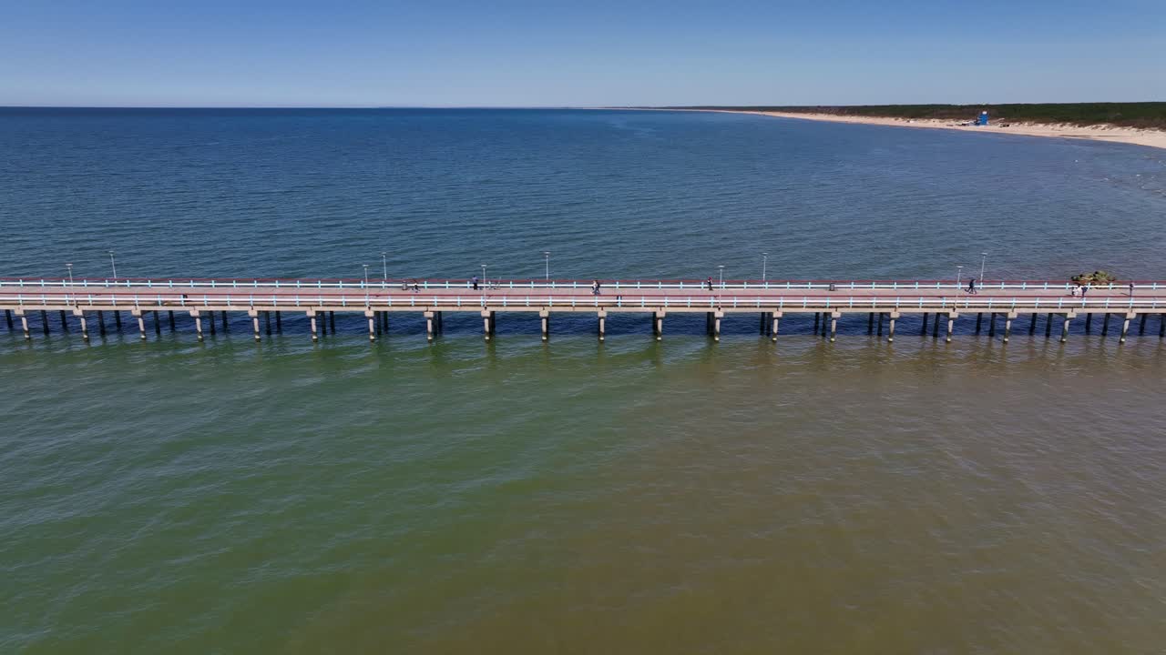 Vista da drone di un ponte che sorge sulla spiaggia di Palanga, che si estende verso il Mar Baltico.