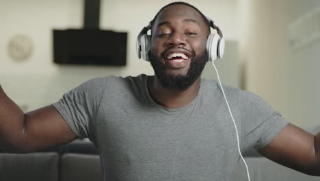 Portrait-of-male-person-singing-in-headphones.-Joyful-adult-listening-music.