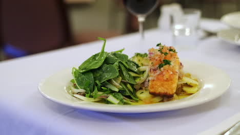 filete de salmón frito sobre patata y ensalada