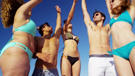 young multi ethnic friends in swimwear on beach