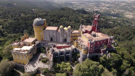 birds eye view of popular tourist destination pena palace in sintra portugal, aerial dolly out shot