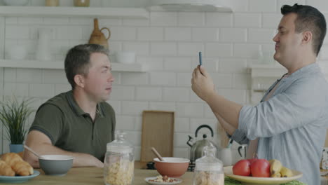 friends taking photos at breakfast in kitchen