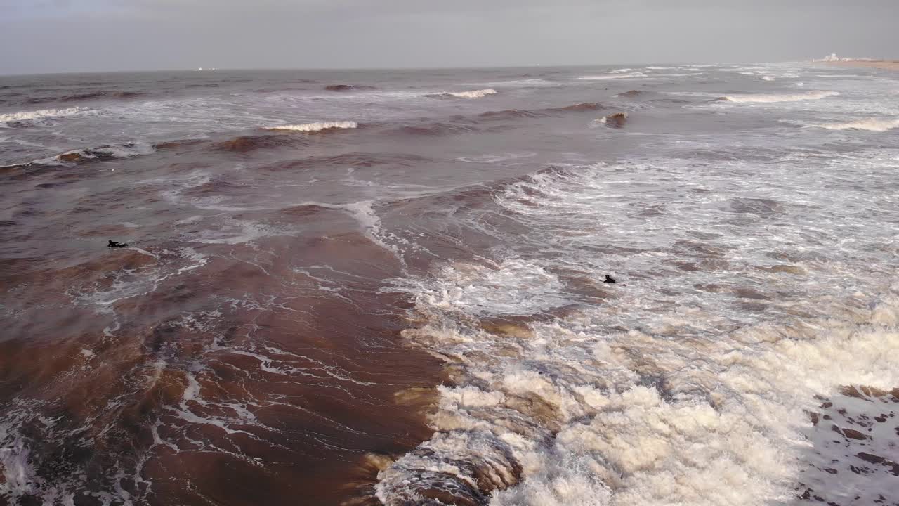 Breaking Waves With People Swimming During Sunset In Katwijk aan Zee, Netherlands