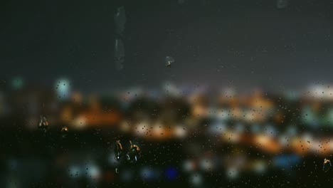 gota de agua en las ventanas con fondo borroso, vista nocturna de la ciudad