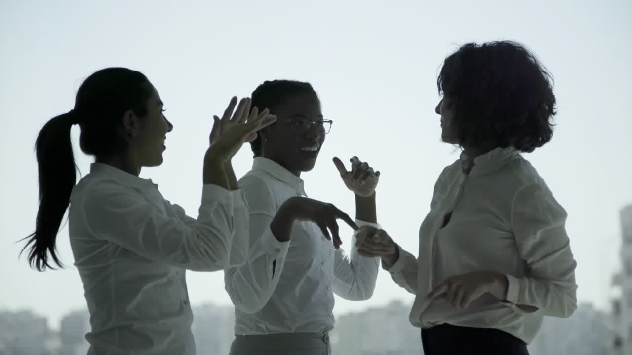 Donne d'affari multietniche felici che ballano