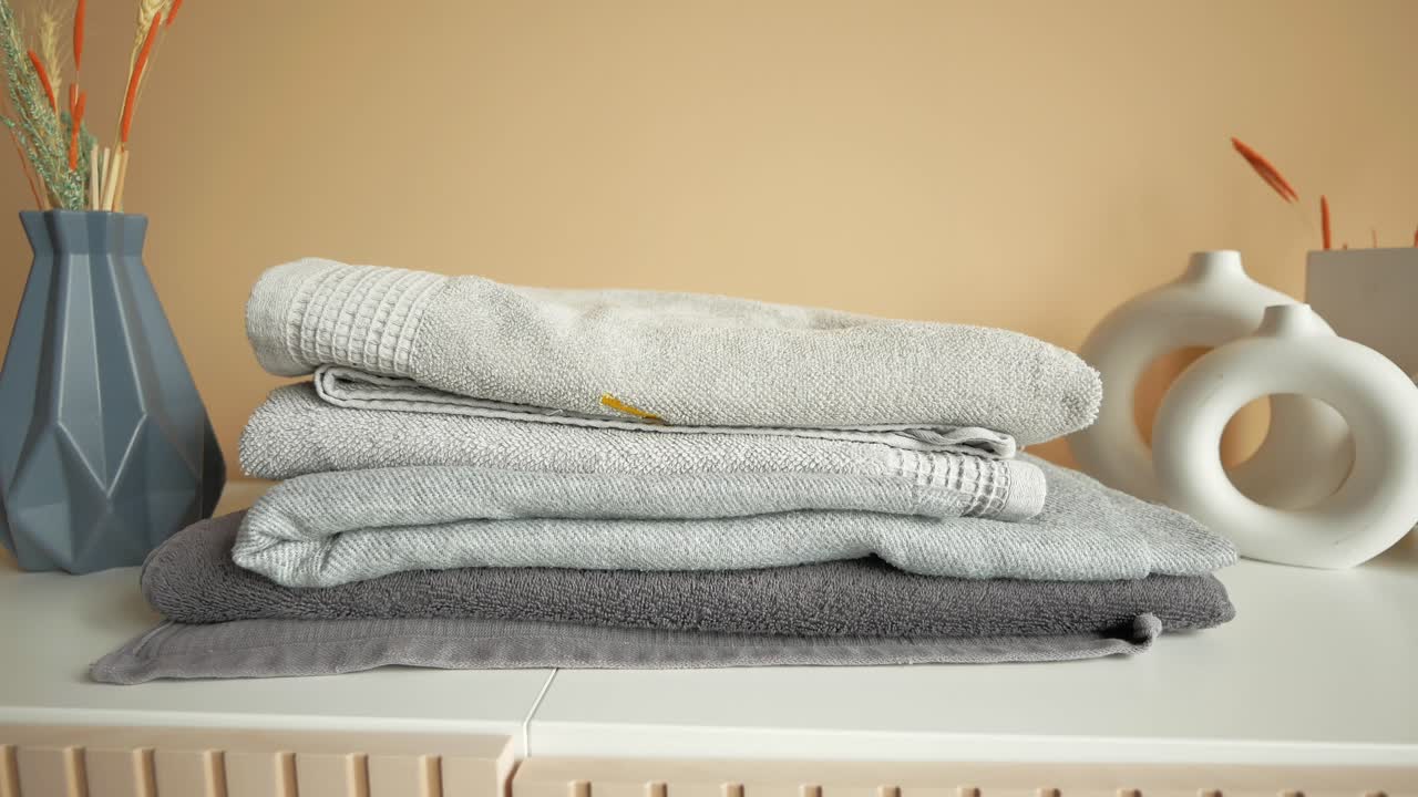 стек серых полотенцев на полке в современной ванной