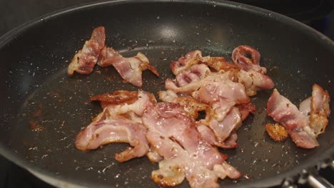 Golden-brown-crispy-bacon-sizzles-in-hot-non-stick-frying-pan,-skillet