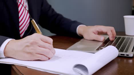 close up businessman use notebook male hands keyboarding laptop using texting pointing networking green screen chroma key chromakey keyboard and write on paper working on the table.