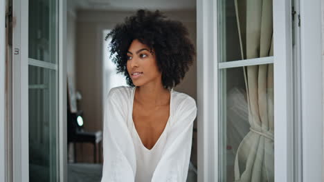 relaxed lady looking window at weekend morning. dark skin woman staring camera