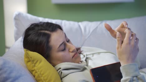 mujer joven cansada y somnolienta adicta al teléfono.