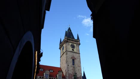 view from dark alley to old town city hall clock tower exterior, prague