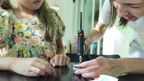 madre e hija haciendo un brazalete juntos